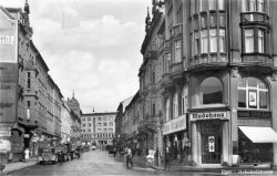 Pohled z křižovatky dnešní ulice Svobody a Evropské. Napravo je zachycen vstup do Módního domu Hanse Stockera, okolo 1940, Sa.
