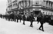 Slavnostní pochod chebský dobrovolných hasičů. Za průvodem je patrný parter domu čp. 7 se vstupem do banky Kreditanstalt der Deutschen, 1. červen 1934, SOkA Cheb.